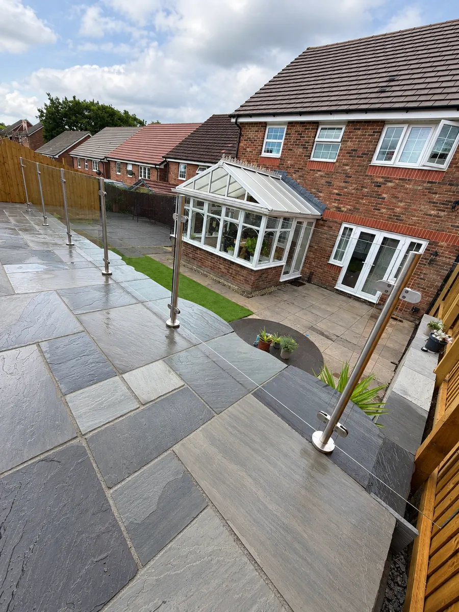 Raised stone slab terrace with glass balustrade
