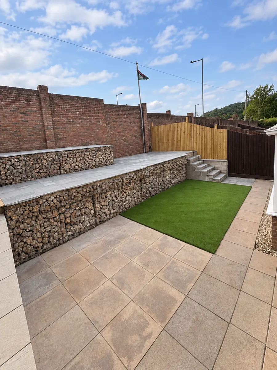 Stone patio, gabion retaining wall, artificial lawn and timber fence
