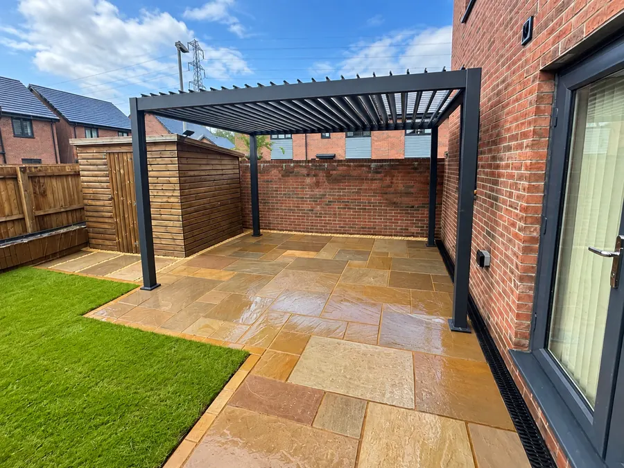 Sandstone patio, pergola, artificial lawn and timber fencing