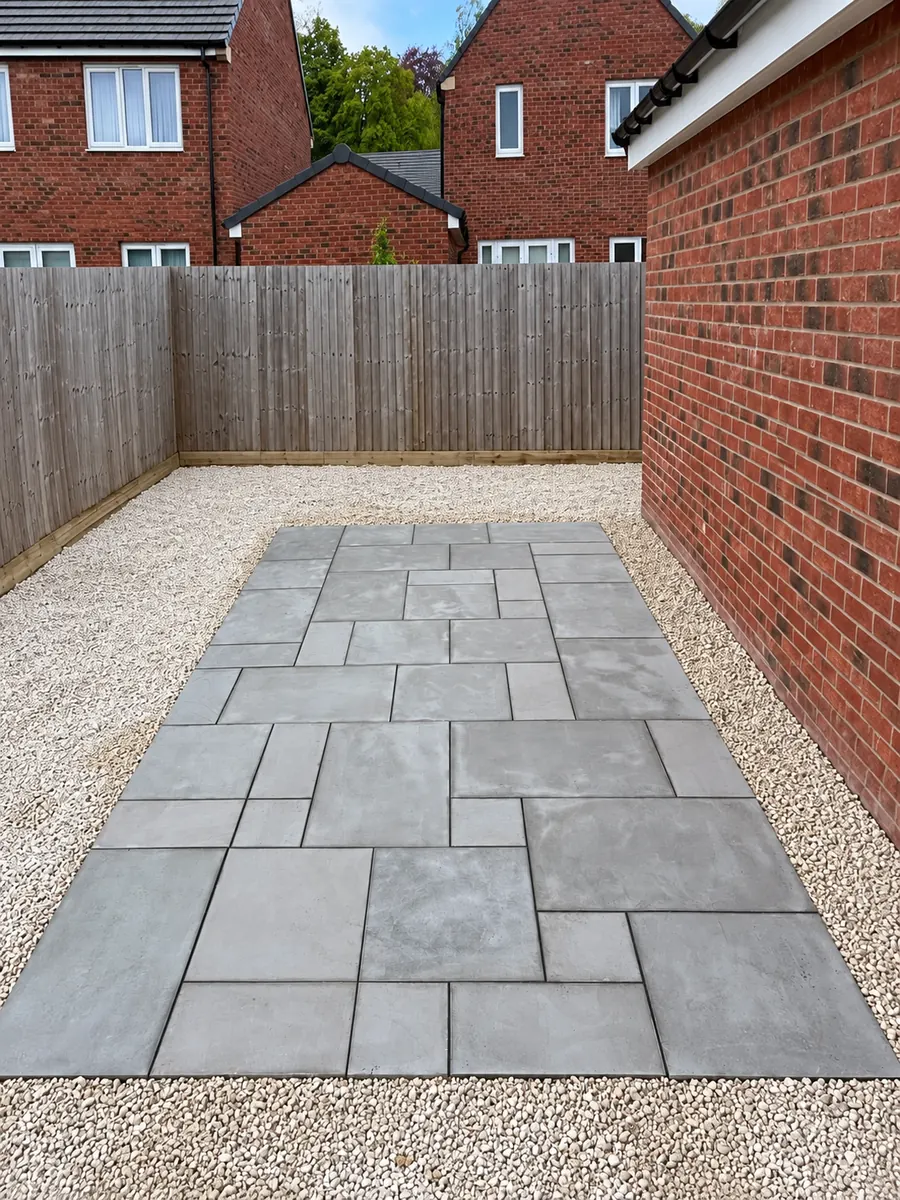 Grey slab patio surrounded by loose gravel, alternate view