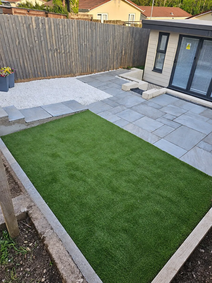 Finished grey slab patio, artificial lawn and white gravel area, alternate view