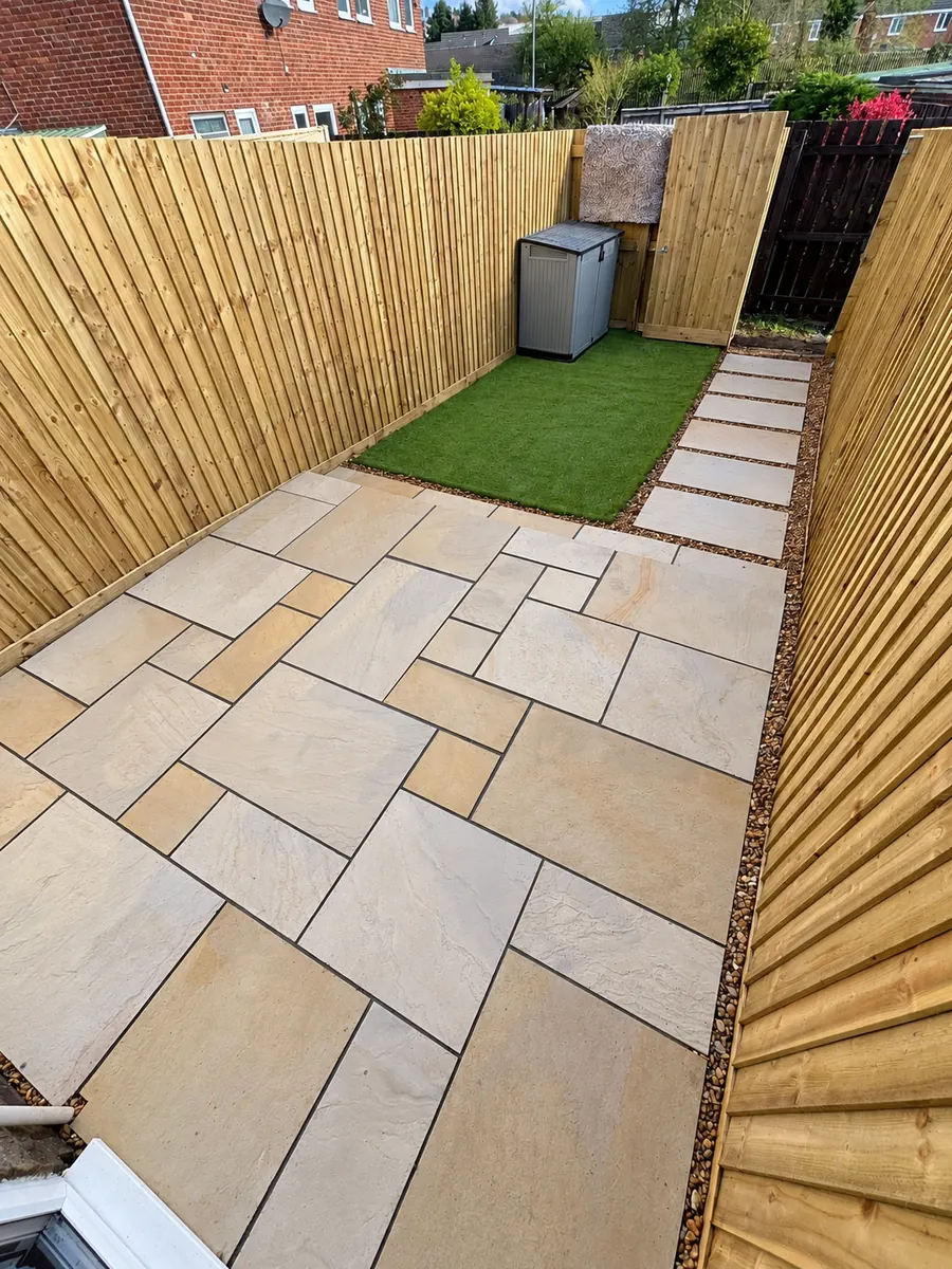 Narrow sandstone patio, artificial lawn and prominent timber fencing
