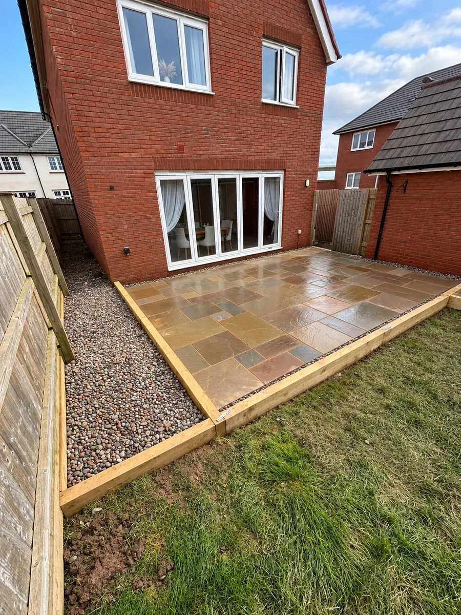 Finished sandstone patio with decorative gravel strip and sleeper edging