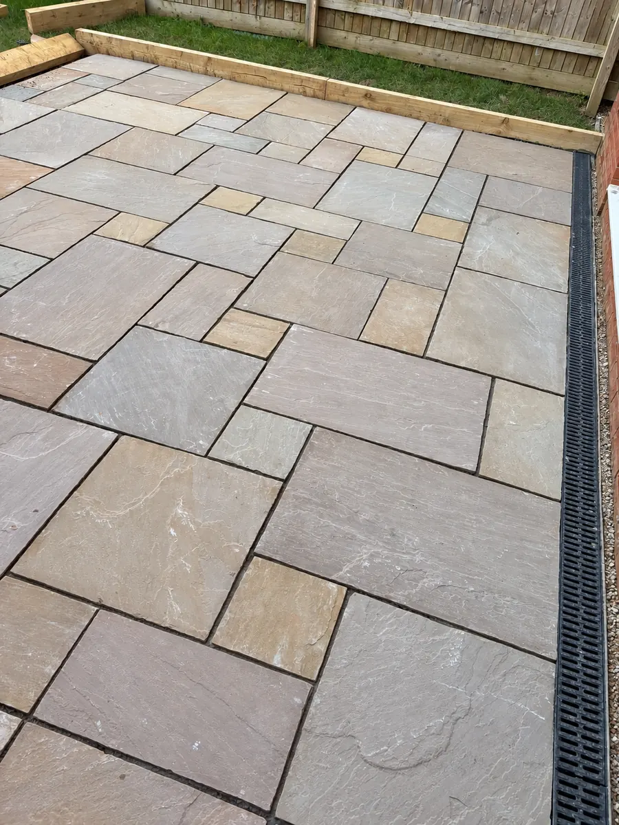 Finished slab surface and clearly visible drainage channel beside house; source stage is During